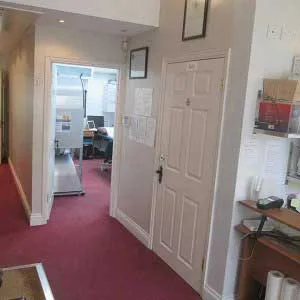Corridor inside Spine Plus Chigwell clinic, with reception area visible